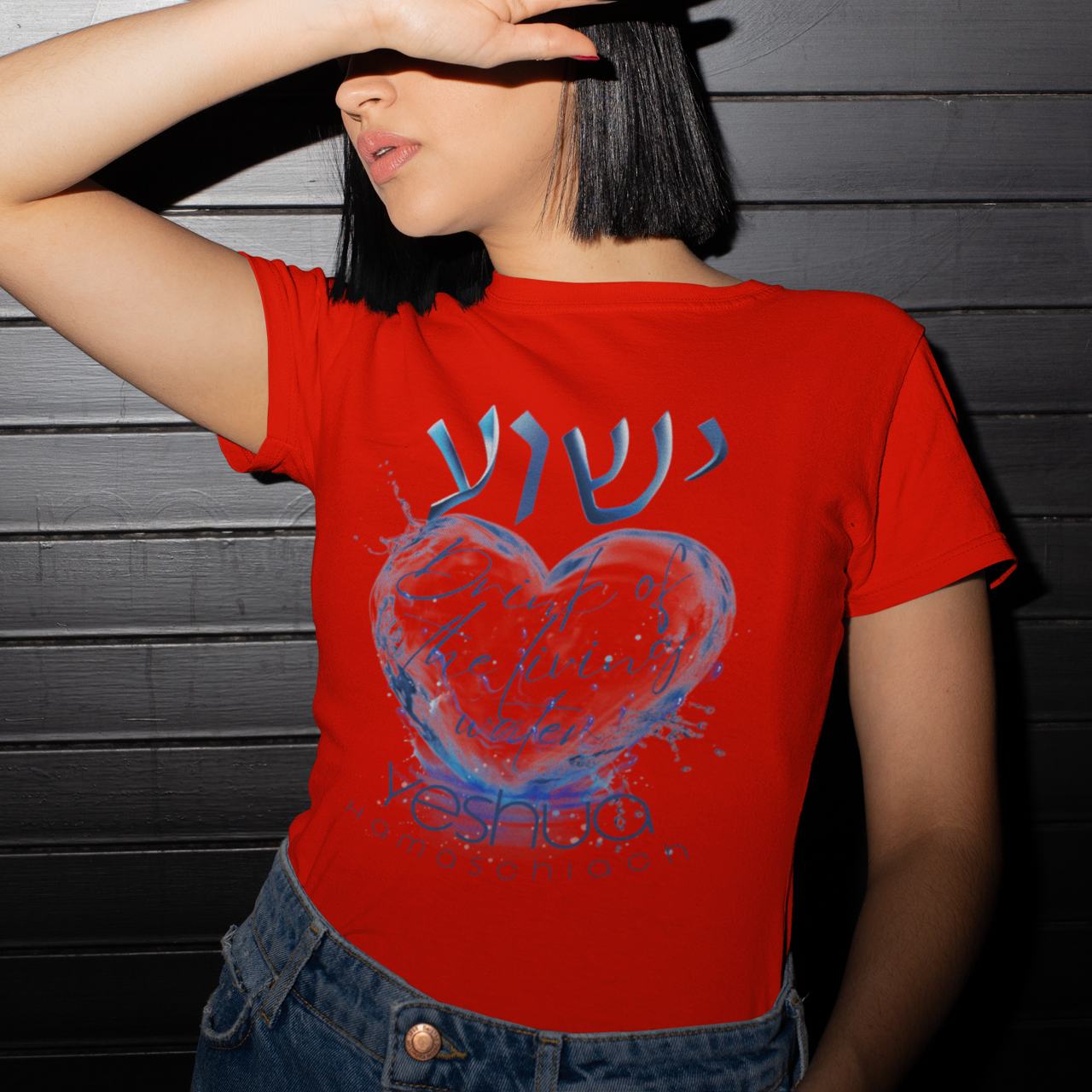 Person wearing a red t-shirt with a blue heart design against a dark wooden background