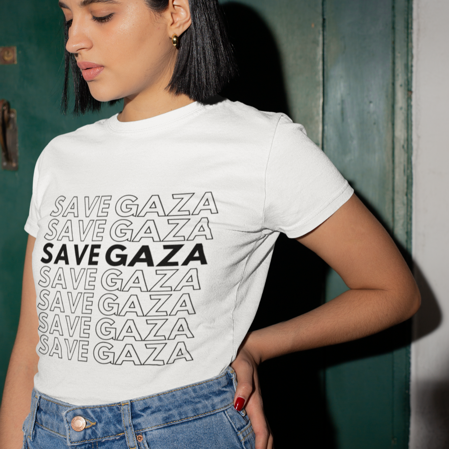 Person wearing a white t-shirt with 'SAVE GAZA' text, standing against a green door.