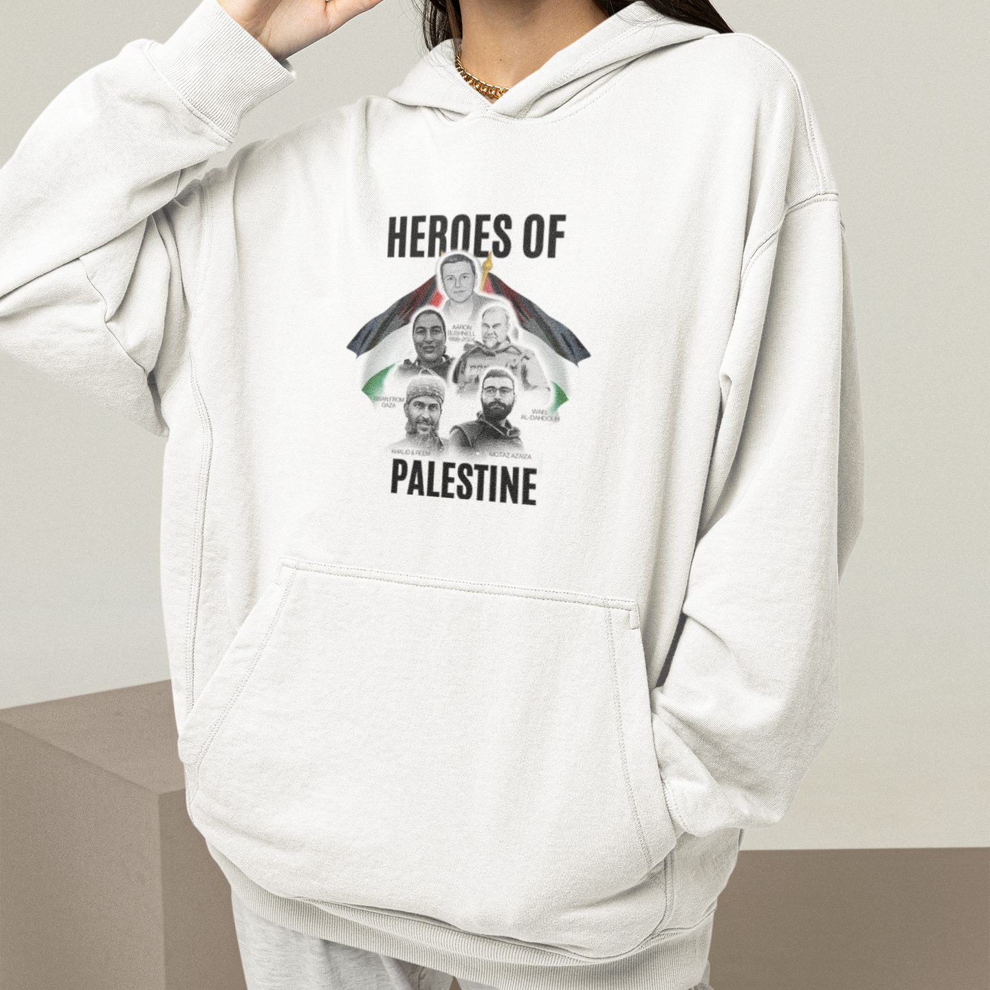 Person wearing a white hoodie with 'Heroes of Palestine' graphic design.