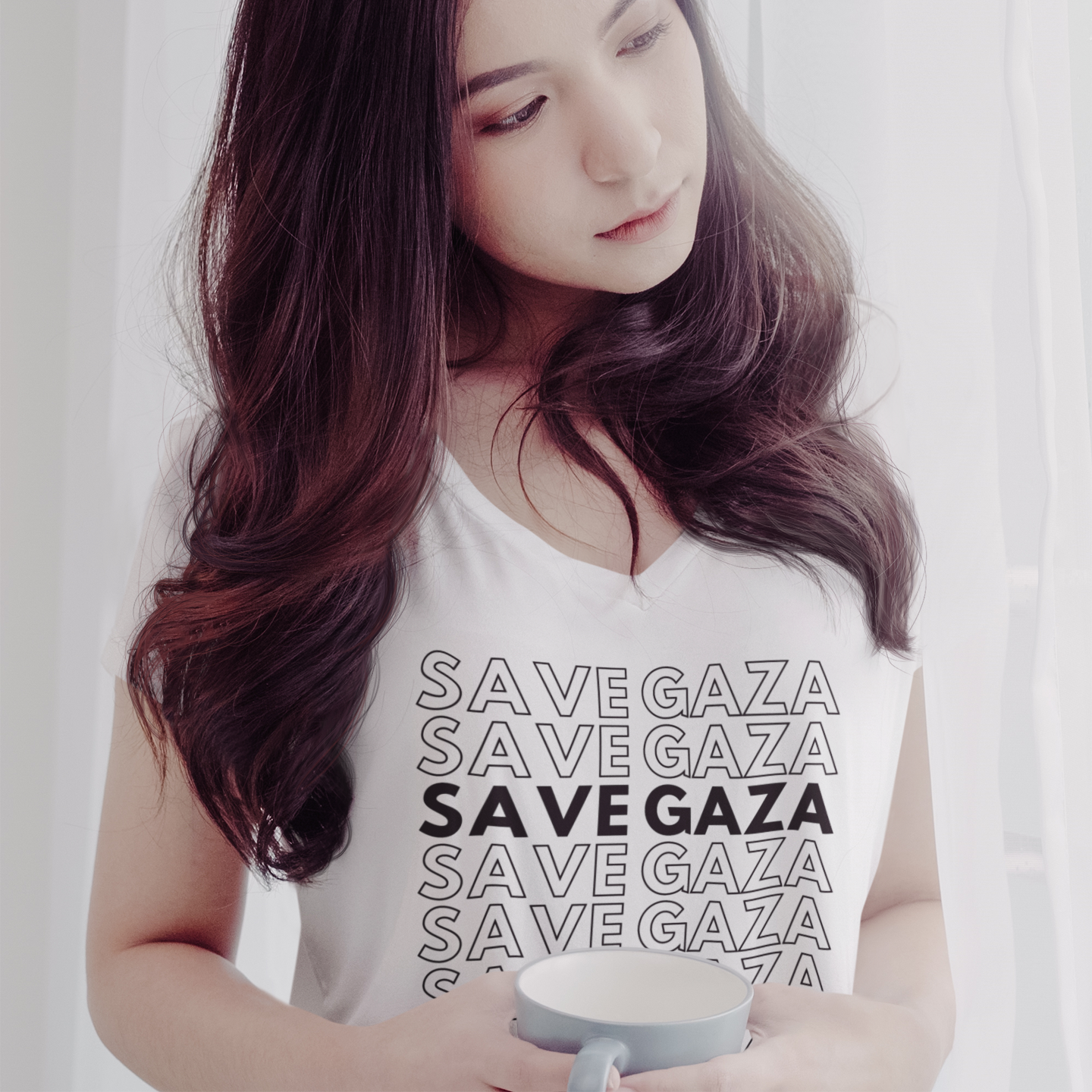 Woman wearing a 'Save Gaza' shirt holding a cup.