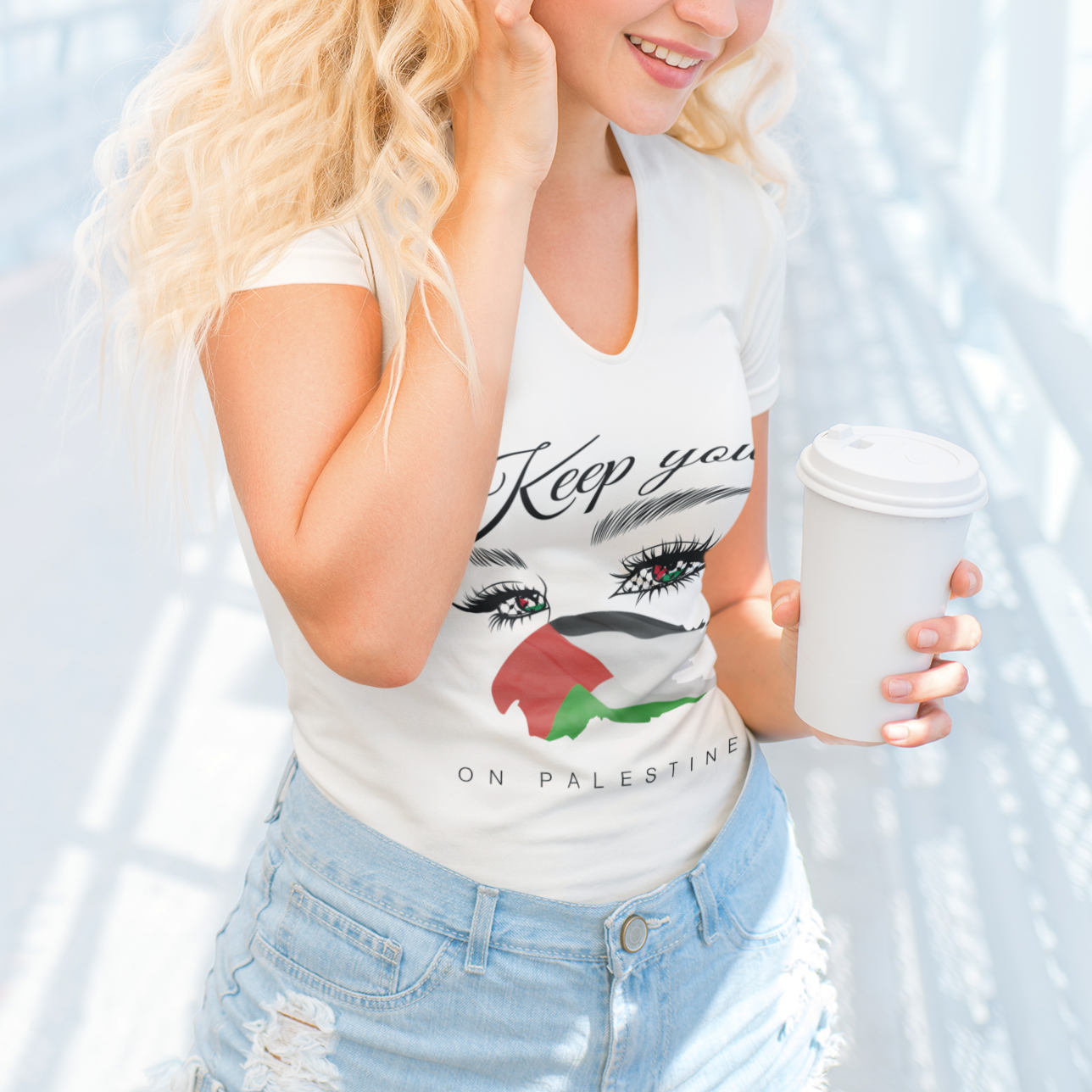 Woman wearing a tank top with a graphic design and holding a coffee cup against a white background