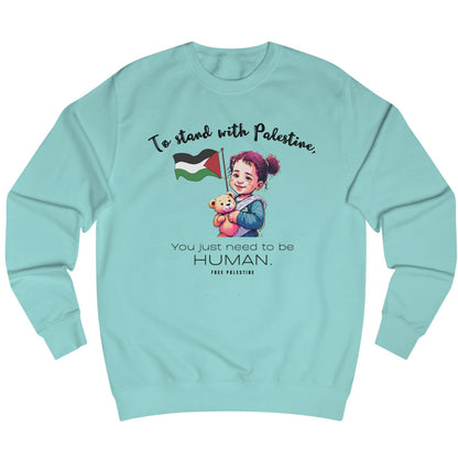 A light blue unisex sweatshirt with text and a graphic. The text reads, 'To stand with Palestine, you just need to be human.