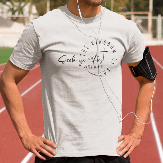 Man on a running track wearing a white t-shirt with text and earphones.
