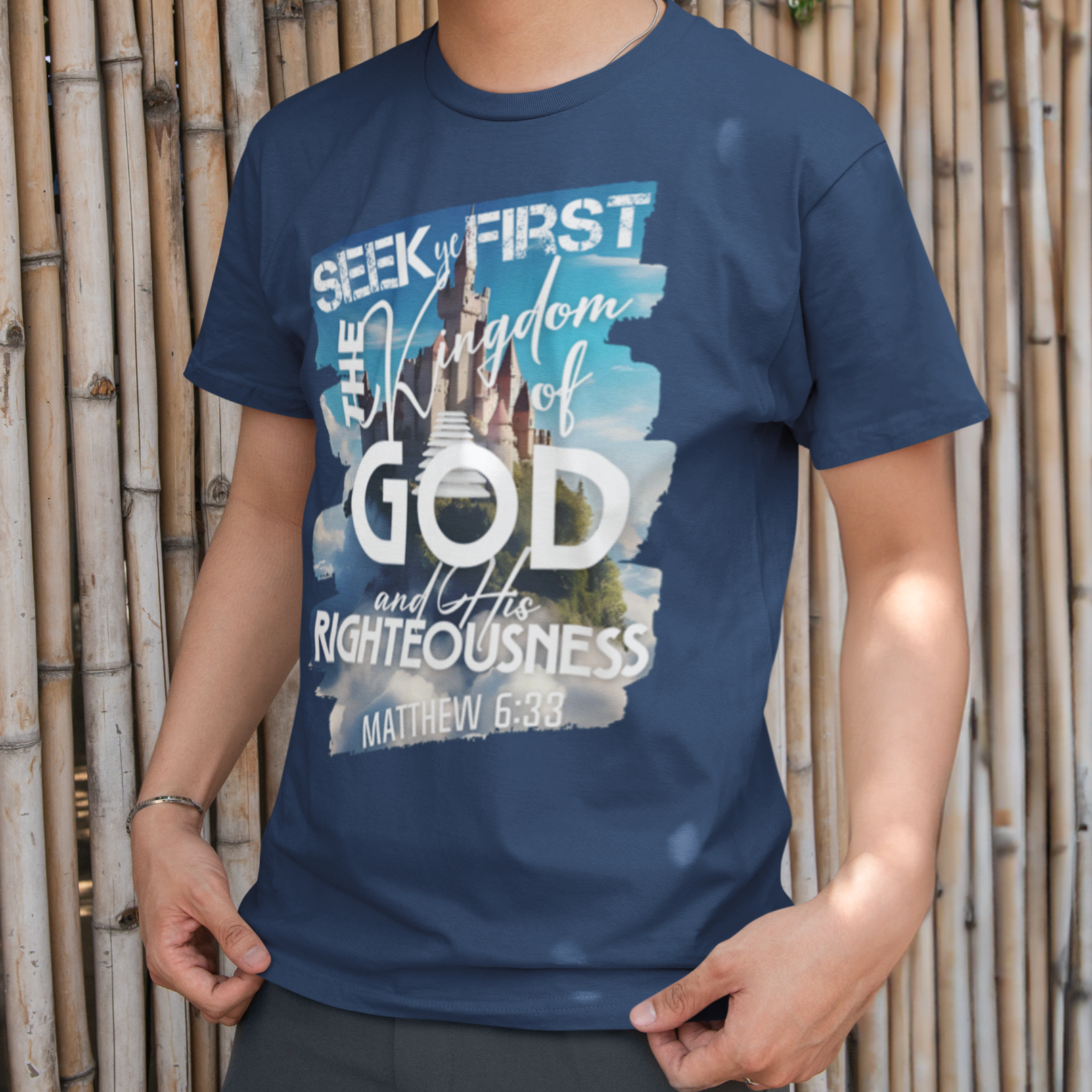 Person wearing a blue t-shirt with text standing against a bamboo wall