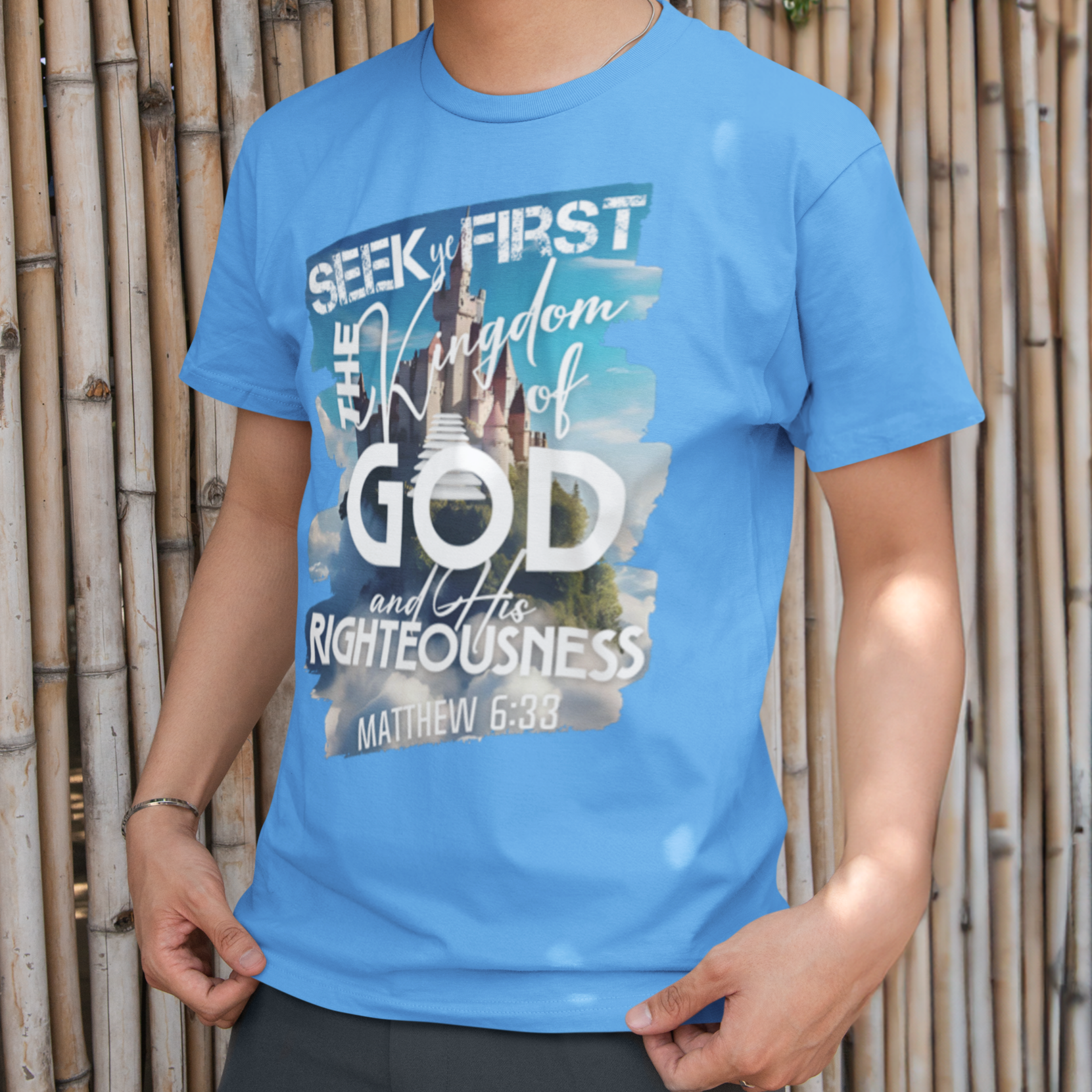 Person wearing a blue t-shirt with a graphic design in front of a bamboo wall