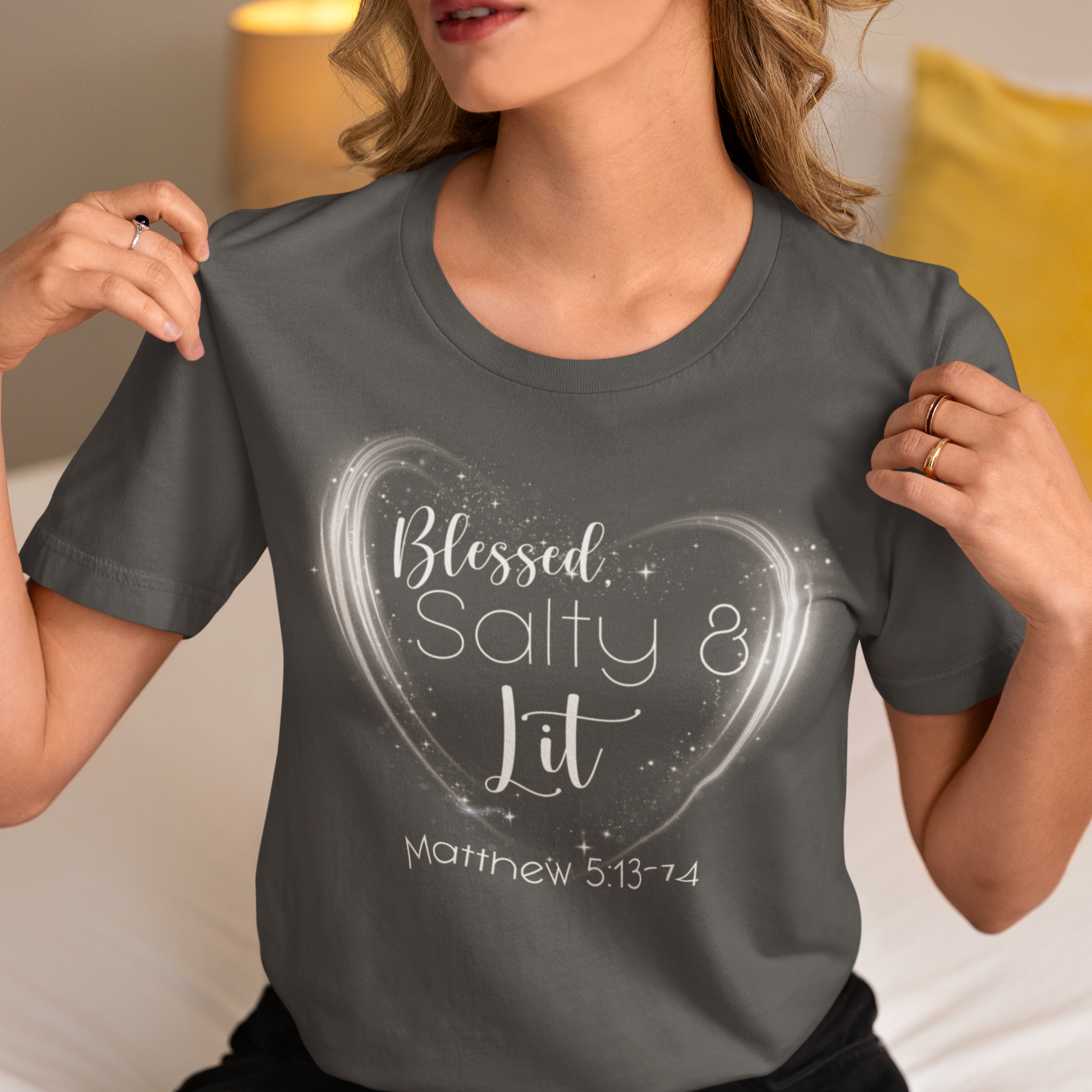 Person wearing a gray t-shirt with 'Blessed Salty & Lit' design