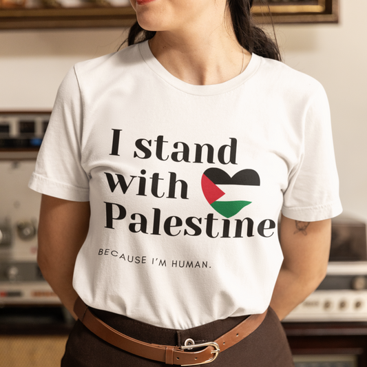 Person wearing a white t-shirt with 'I stand with Palestine' text and Palestinian flag design.