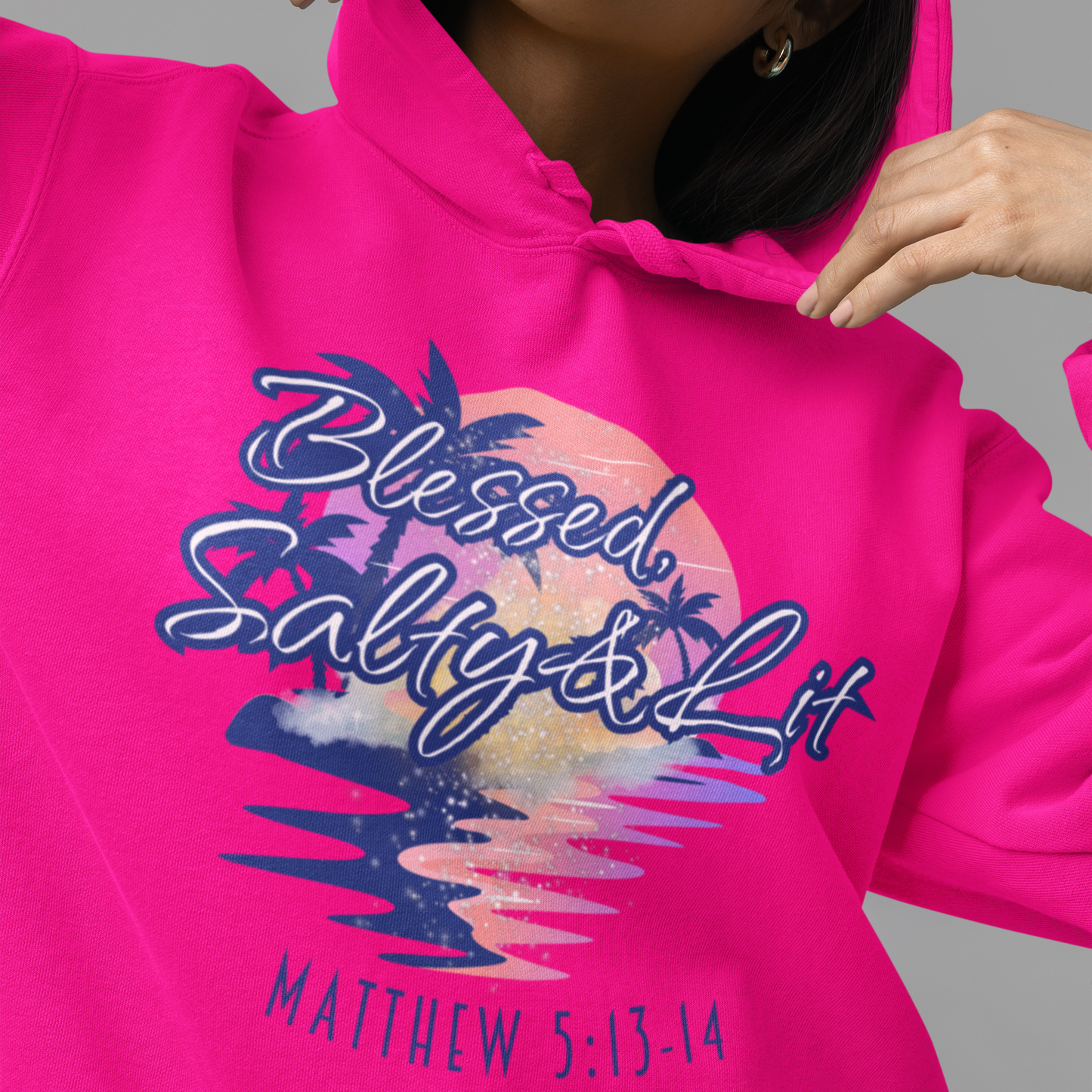 Person wearing a bright pink hoodie with a graphic design and text.