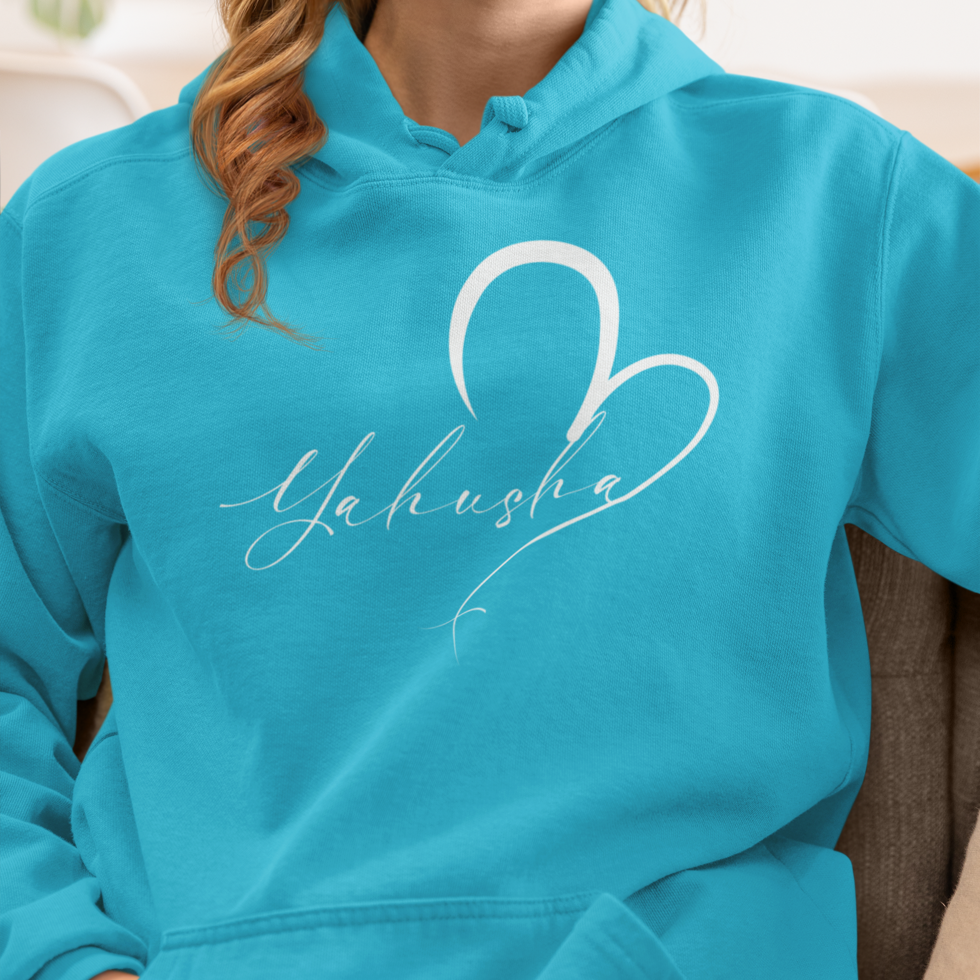 Person wearing a turquoise hoodie with 'Yahusha' design