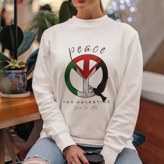 Woman wearing a white sweatshirt with a peace symbol design, sitting in a cafe.