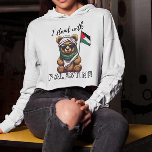 Person wearing a white hoodie with a graphic design sitting on a bench in an indoor setting.