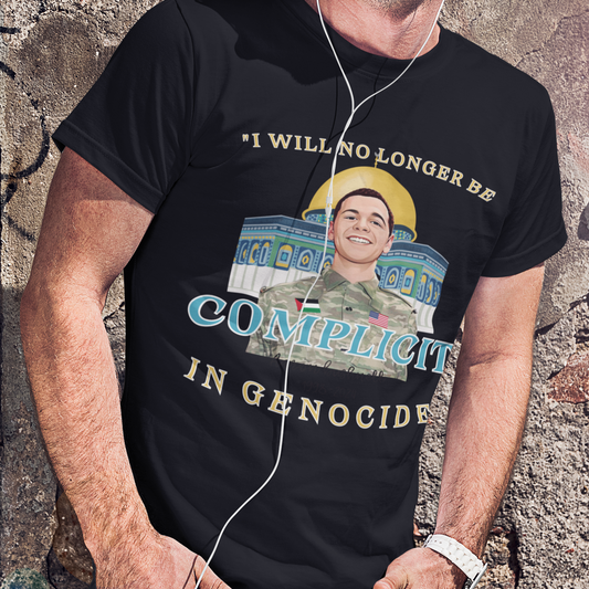 Person wearing a black t-shirt with graphic and text against a textured wall.