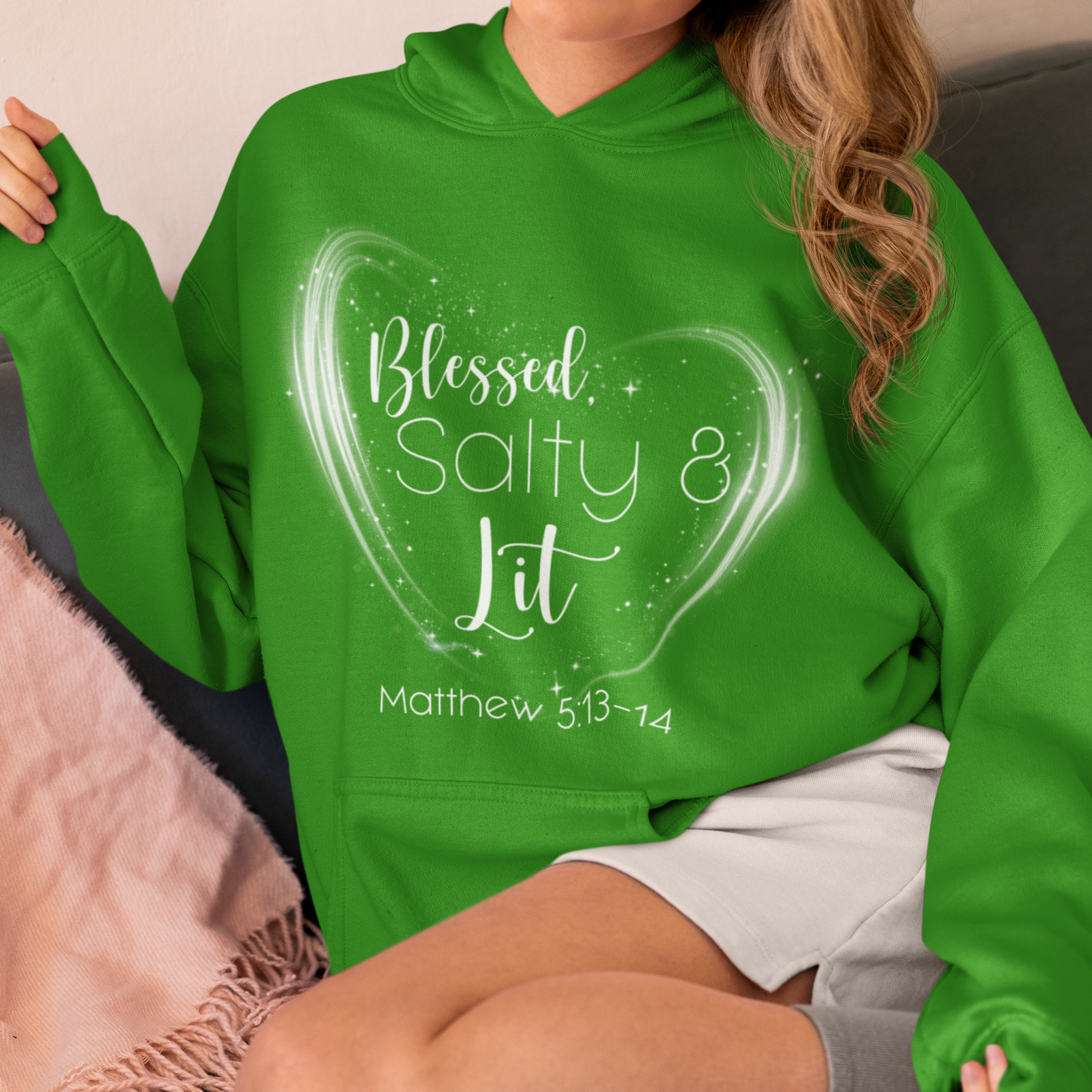 Person wearing a green hoodie with text design sitting on a couch.