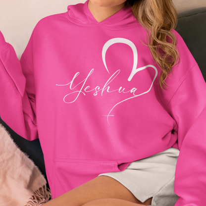 Person wearing a pink hoodie with 'Yeshua' and a heart design.
