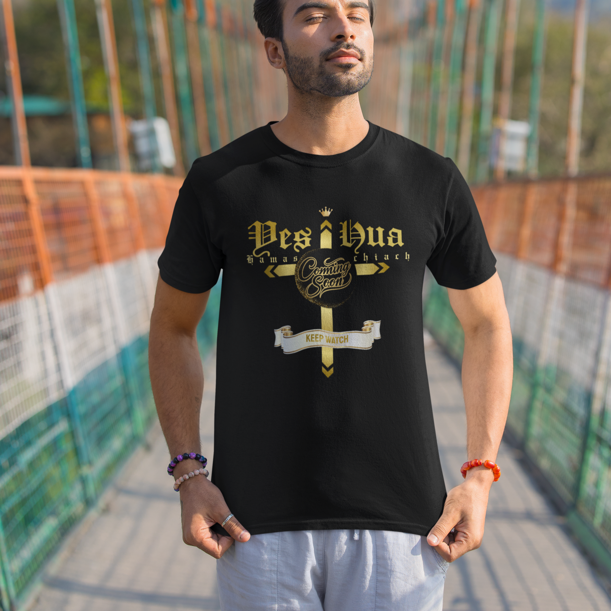 Man wearing a black t-shirt with 'Desi Bua' design on a suspension bridge