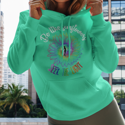 Woman wearing a green hoodie with colorful text and graphics, standing in an urban setting.