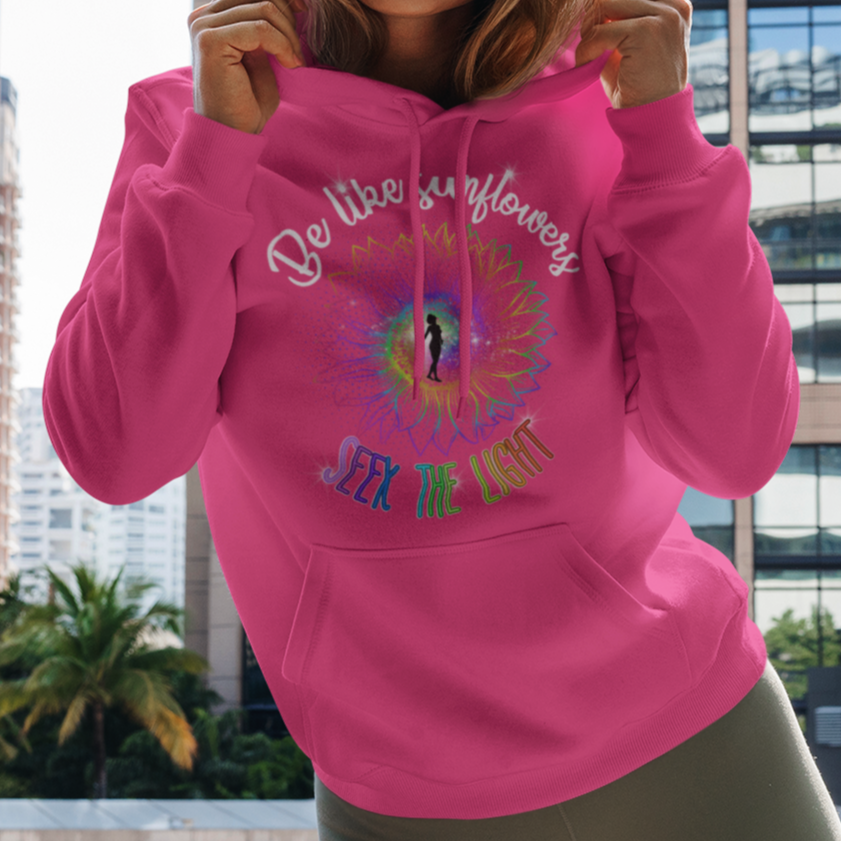 Woman wearing a pink hoodie with text and graphics in an urban setting