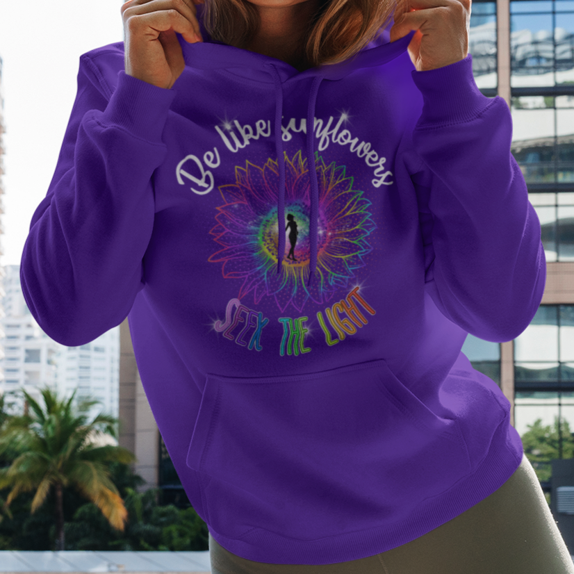 Woman holding a purple hoodie with text and graphics in an urban setting