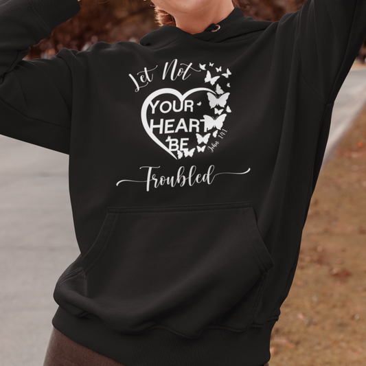 Woman wearing a black hoodie with a motivational quote, standing outdoors.