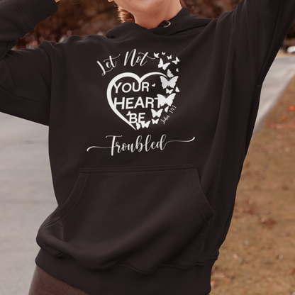 Woman wearing a black hoodie with a heart design and text, standing outdoors.