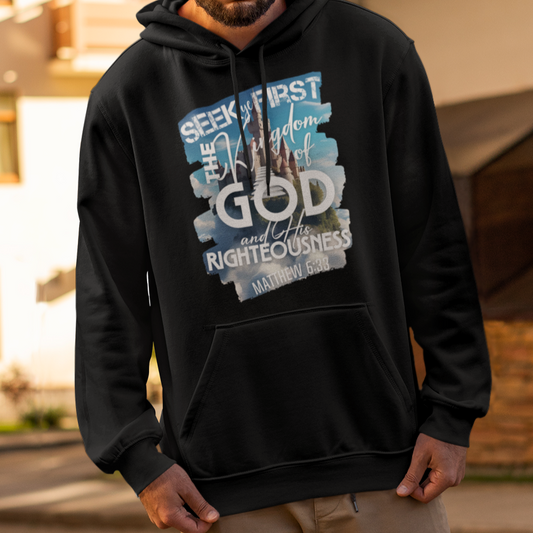 Man wearing a black hoodie with text and graphics, standing on a street.