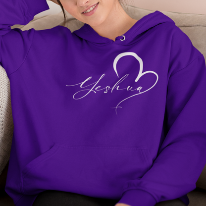 Woman wearing a purple hoodie with 'Yeshua' design sitting on a couch.