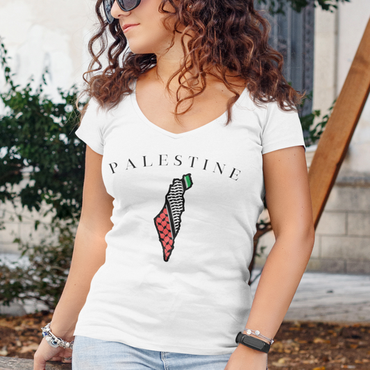 Woman wearing a white t-shirt with 'PALESTINE' and a map design outdoors.