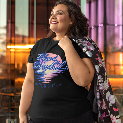 Woman wearing a black t-shirt with colorful graphics and text, standing in an urban setting.