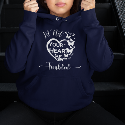 Person wearing a navy blue hoodie with text and butterfly design, sitting on stairs.