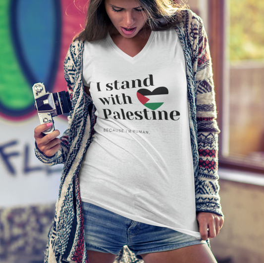 Woman wearing a 'I stand with Palestine' shirt in front of a colorful mural.