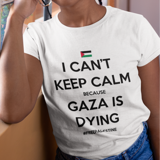 Woman wearing a white t-shirt with a message about Gaza, standing indoors.