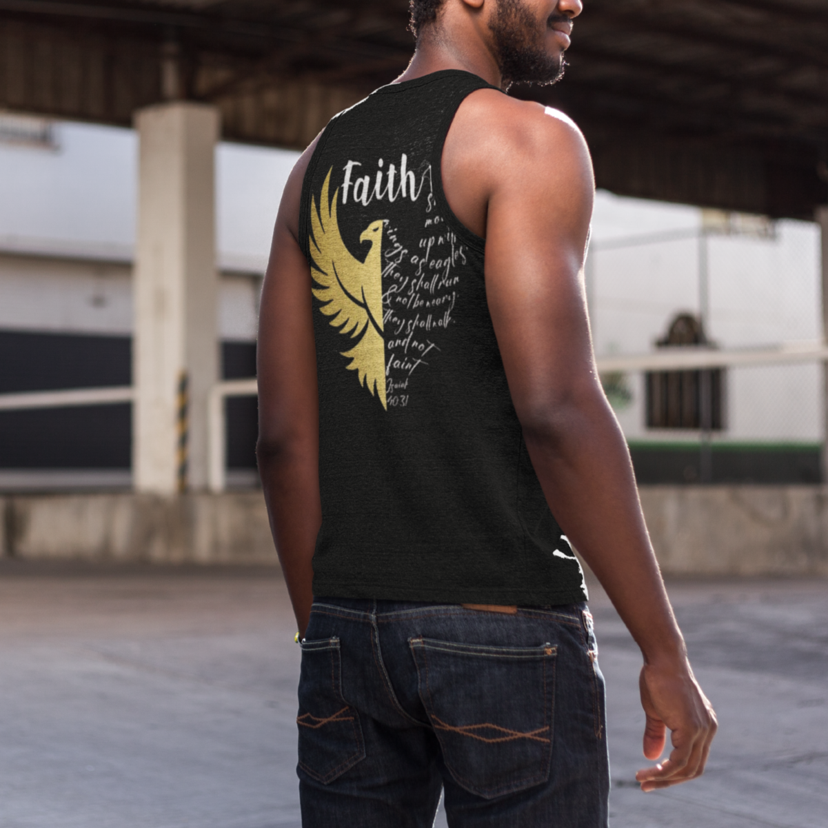 Man wearing a black sleeveless shirt with a yellow eagle design and 'Faith' text, standing outdoors.