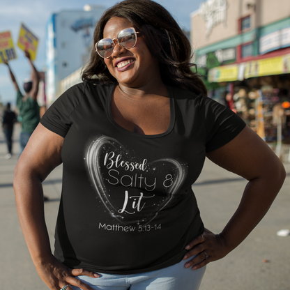 Woman wearing a black t-shirt with text, standing on a street with palm trees and buildings in the background.