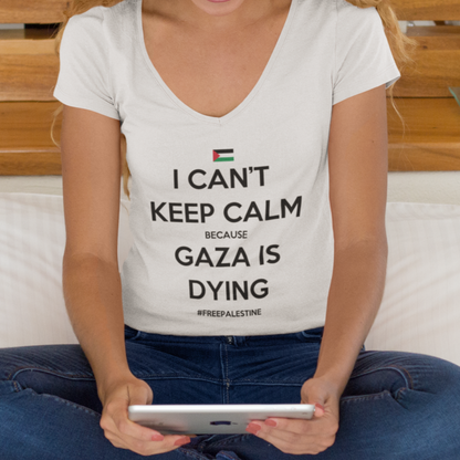 Woman sitting on a bed wearing a t-shirt with a message about Gaza, using a tablet.
