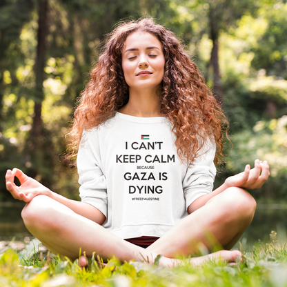 Woman meditating outdoors wearing a shirt with a message.