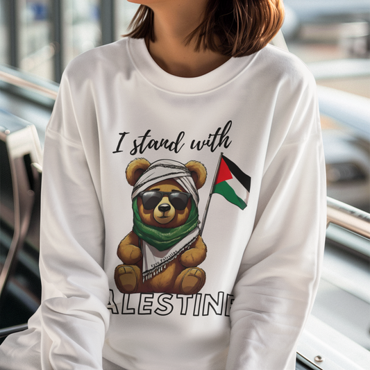 Woman wearing a white sweatshirt with a bear holding a Palestinian flag and 'I stand with Palestine' text.