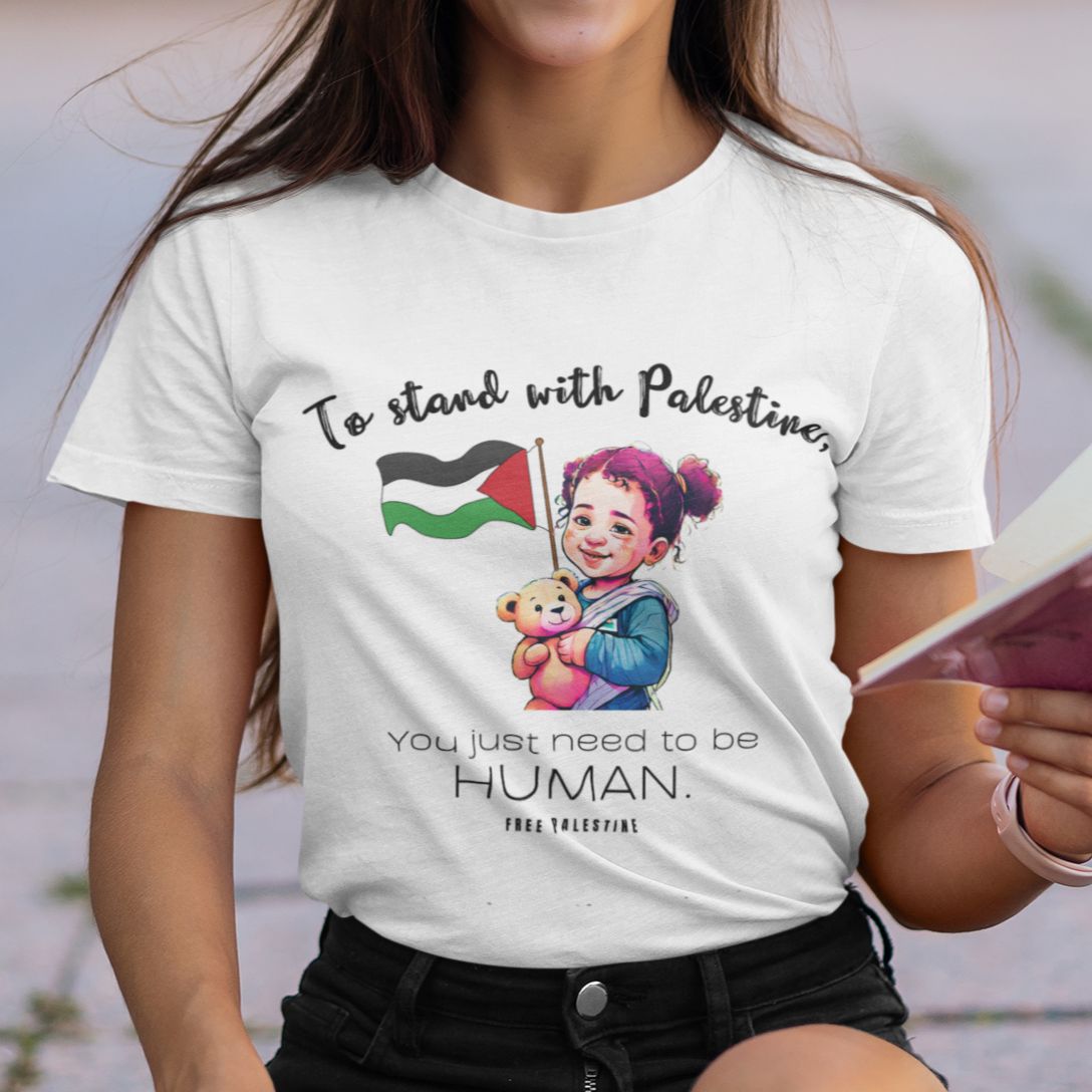 Woman wearing a t-shirt with a message supporting Palestinians, sitting outdoors.