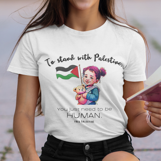 Woman wearing a t-shirt with a message supporting Palestinians, sitting outdoors.