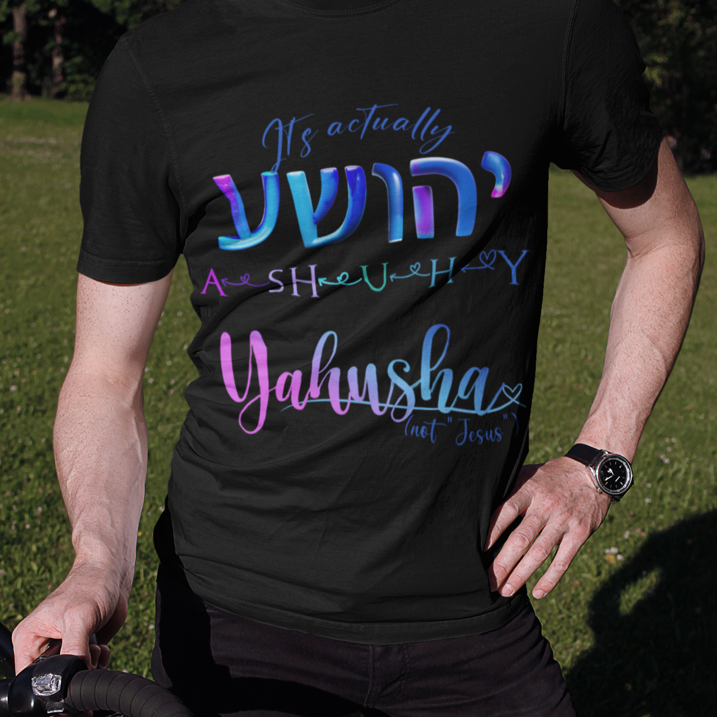 Person wearing a black t-shirt with colorful text outdoors