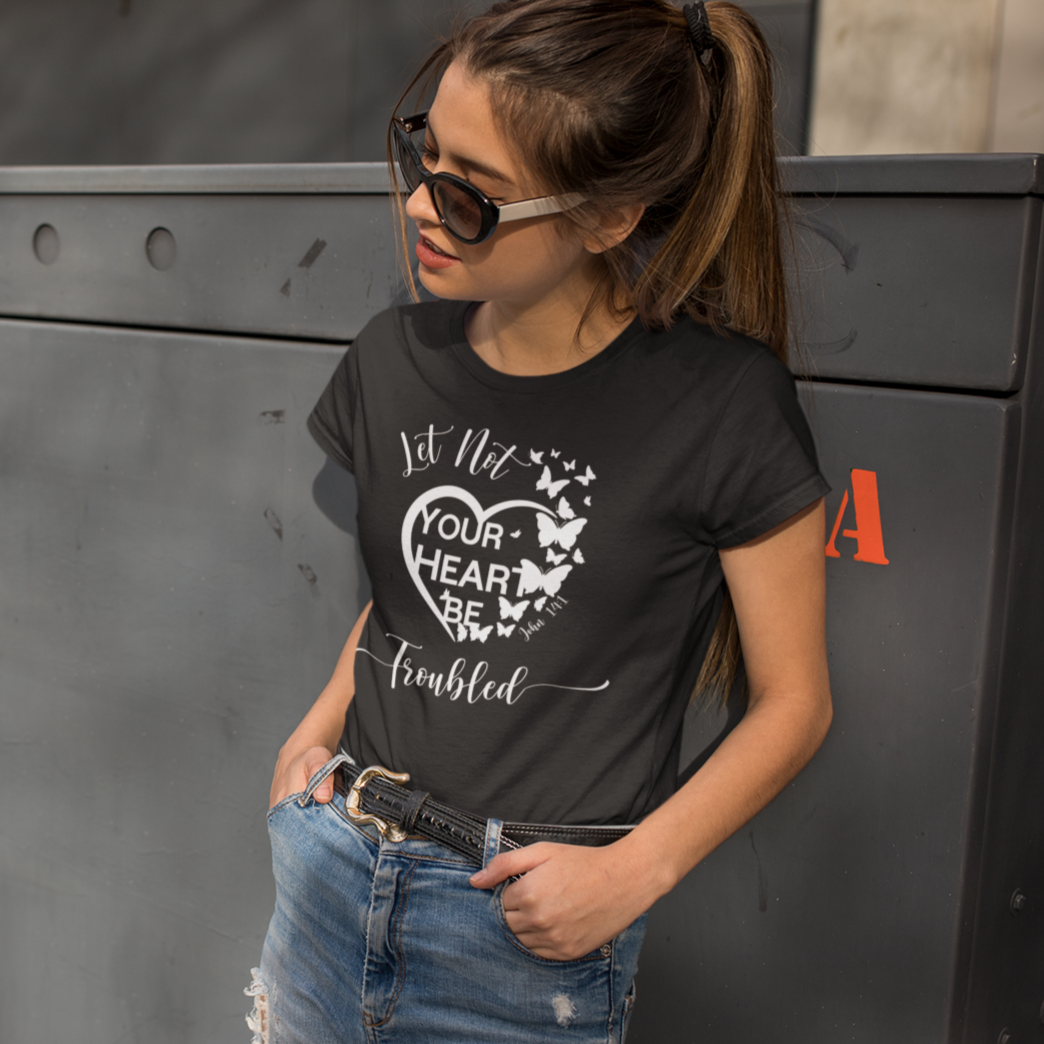 Woman wearing a black t-shirt with a graphic design, standing next to a large metal box.
