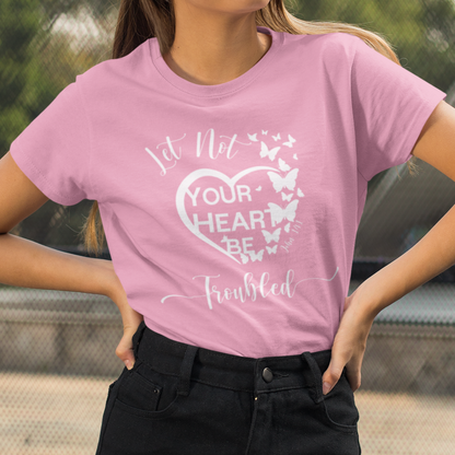 Person wearing a pink t-shirt with a graphic design and text, standing outdoors.
