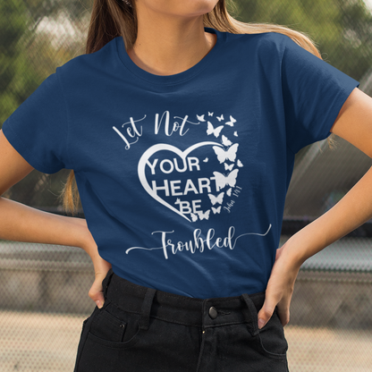 Woman wearing a blue t-shirt with a heart design and text outdoors.
