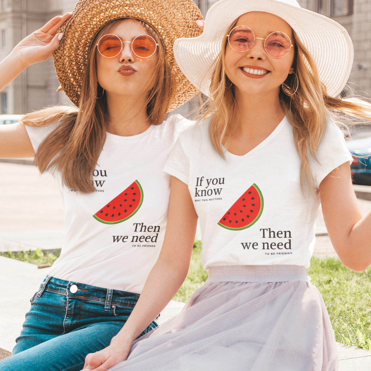 Two women sitting outdoors wearing matching t-shirts with watermelon graphics and text.
