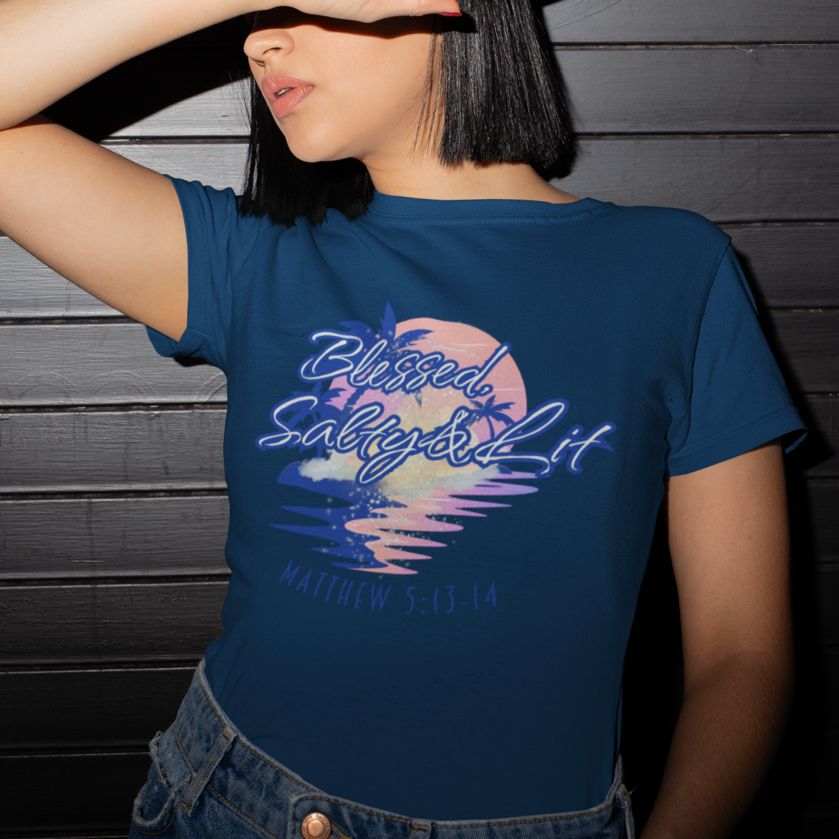 Person wearing a blue t-shirt with a colorful graphic design against a dark wooden background