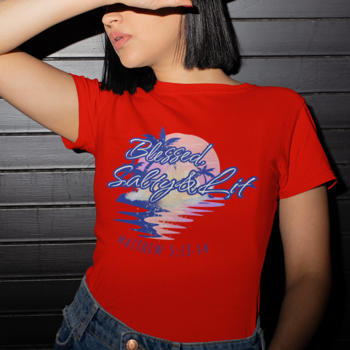 Person wearing a red t-shirt with a graphic design against a dark wooden panel background